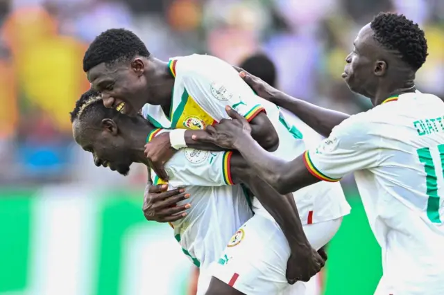 Senegalese midfielder Lamine Camara celebrates with teammates after scoring the third goal in a 2024 Africa Cup of Nations group C match against Gambia at Stade Charles Konan Banny, Yamoussoukro, January 15, 2024.