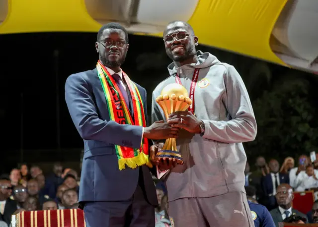 President Bassirou Diomaye Faye and captain Khalidou Koulibaly holding the Africa Cup trophy together