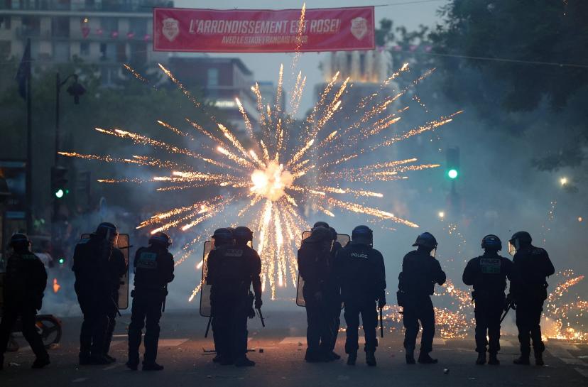 Fireworks explode in front of riot police in Paris on Saturday evening.