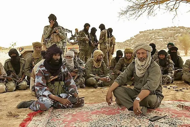 Touareg fighters gathered under a tree during a desert gathering