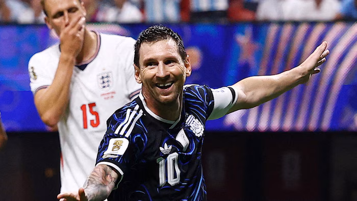 A smiling soccer player facing a dejected opponent